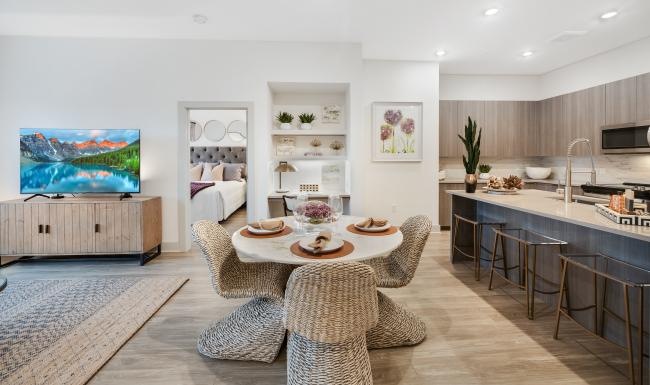 a large living room with a tv table and chairs